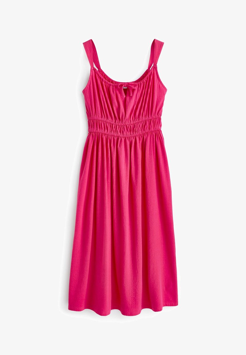 Robe rose vif sans manches avec larges bretelles, taille élastique, corsage froncé et jupe fluide longueur genou sur fond blanc.