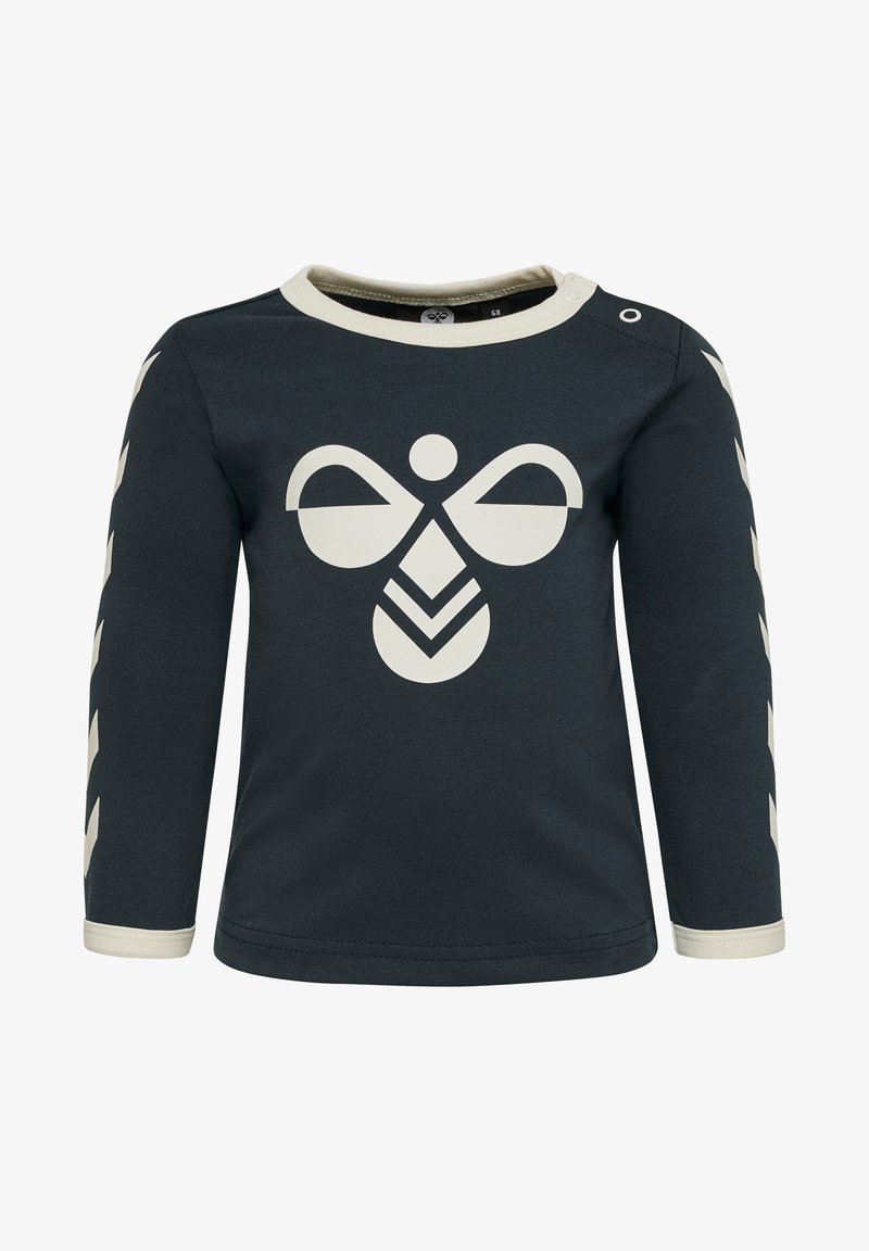 Ciemnoniebieska koszula z długim rękawem z kremowymi akcentami; ma duże kremowe logo na środku oraz wzorzyste rękawy z detalem w zygzak.