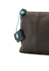 Borsa in pelle marrone con finitura a ciottoli, dotata di un bottone di accento turchese e un'etichetta in pelle nera, caratterizzata da una cucitura a contrasto lungo la cucitura.