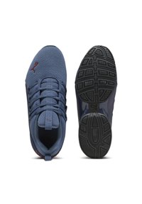 Zapatillas de malla azules con un upper texturizado, cordones destacados y una suela de goma negra con un dibujo en el perfil. Acento de logo rojo.