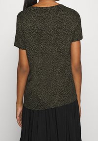 Olivově zelená halenka s leopardím vzorem, krátkými rukávy, kulatým výstřihem a volným střihem, vyrobená z měkké, lehké tkaniny.