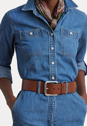 Denim skjorte med knapper, to brystlommer, op-rullede ærmer, et brunt læderbælte og et halsørklæde med blomsterprint.