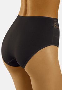Culotte noire taille haute en tissu lisse avec une accent en dentelle à l'arrière, offrant une couverture intégrale et une apparence sans couture.