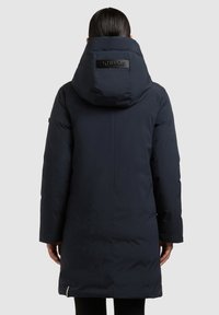 Abrigo acolchado azul marino con capucha, que cuenta con un gran cuello, parche con logo en la espalda, mangas largas y bolsillo con cremallera en el dobladillo.