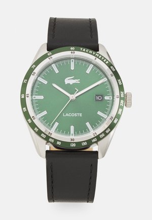 Montre masculine avec un cadran vert, boîtier en acier inoxydable, bracelet en cuir noir, index argentés et affichage de la date à 3 heures.