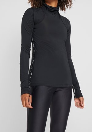Black long-sleeve top with a cowl neck, made of stretchy fabric. Features white text along the sides and fitted design. Worn with glossy leggings.