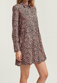 Vestido de leopardo rosa con cuello, mangas largas y detalle de cintura fruncida. Hecho de una tela lisa y ligera.