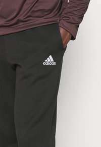 adidas Sportswear ESSENTIALS - Teplákové kalhoty - black