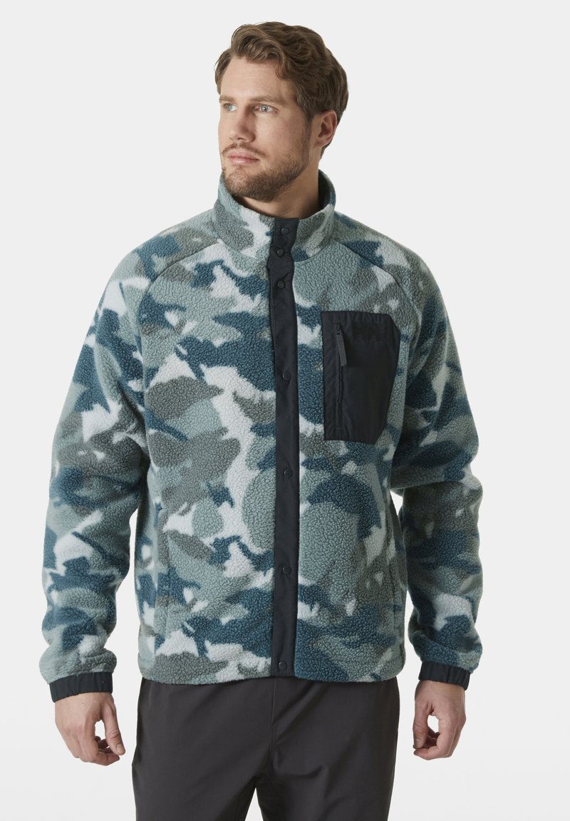 Chaqueta de forro polar en estampado de camuflaje verde y azul, con un bolsillo en el pecho negro, cierre a presión y puños acanalados para una comodidad óptima.