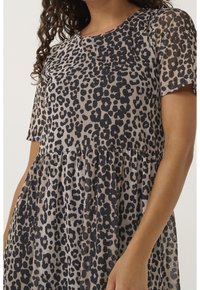 Sheer leopard print dress with a round neckline, short sleeves, and a gathered skirt. Colors include beige, black, and dark brown.