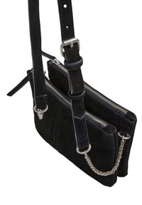 Czarna suwadełkowa torba na ramię z dwoma zamykanymi na zamek komorami, regulowanym paskiem, srebrnymi elementami i łańcuszkiem po boku.