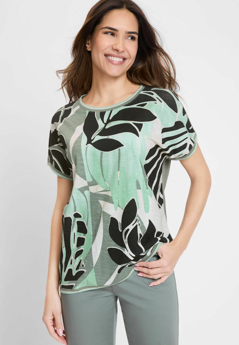 Short-sleeve green t-shirt featuring a black and green abstract leaf pattern, round neckline, and a relaxed fit. Soft, lightweight fabric.