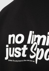 Tissu noir avec un grand texte blanc disant « no limit just Spo » et un texte plus petit en dessous mentionnant « Smilodox : La seule limite est celle que vous vous imposez. »