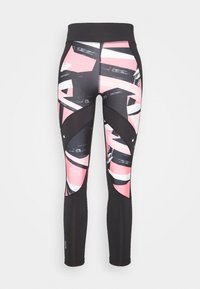 Sorte leggings med et farverigt abstrakt mønster i pink, hvid og sort. Indeholder detaljer med udskæringer på siderne samt en høj talje.