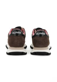 Un paio di sneakers in suede marrone con linguette nere sul tallone che mostrano la scritta "SUN68" in bianco, suole bianche e fodera interna rosa, viste dalla parte posteriore.