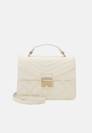 Cremefarbene gesteppte Handtasche mit goldfarbenem Verschluss, Tragegriff oben und abnehmbarem Schulterriemen auf weißem Hintergrund.