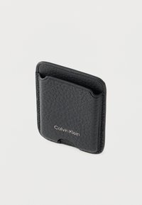 Μαύρη δερμάτινη θήκη καρτών με υφή επιφάνειας, διακριτικό λογότυπο και δύο πλαϊνές θήκες για κάρτες. Απλός, ορθογώνιος σχεδιασμός.