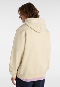 Felpa color crema con cappuccio regolabile, maniche lunghe e vestibilità rilassata. Tessuto morbido con una texture liscia.