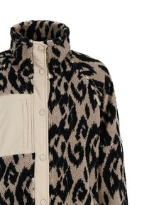 Bež i crni leopard uzorak na flis jakni s visokim ovratnikom, zatvaranjem na dugmiće i bež zip-zatvaračem na prsnom džepu.