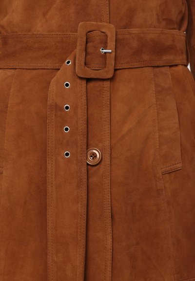 Abito in suede marrone con cintura, dotato di una fibbia rettangolare, chiusura a bottone a pressione e tasche foderate con dettagli di cucitura visibili.