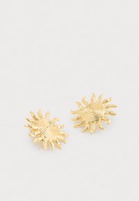 Zlate uhane v obliki sonca z spiralnim središčem in valovitimi žarki, ki imajo teksturirano površino in gladke poudarke.