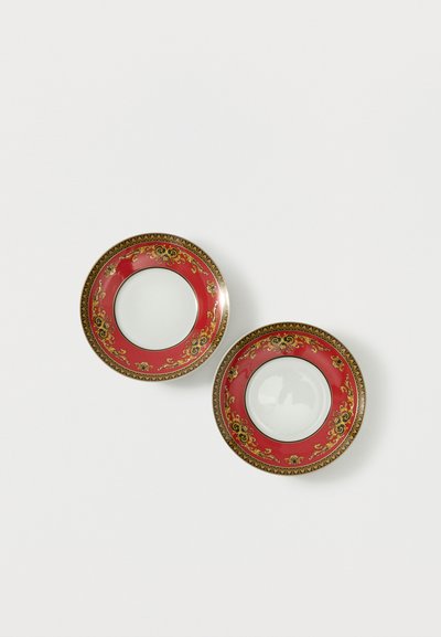 Deux soucoupes en porcelaine vides avec des bordures décoratives ornées de rouge, or et noir sur un fond blanc.