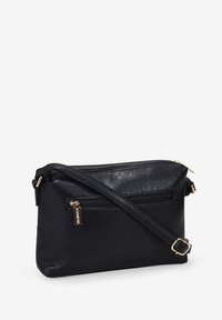 Bolso bandolera de imitación piel negra con dos compartimentos con cremallera, correa ajustable y detalles en dorado. Textura suave y forma rectangular.