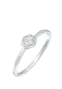 Anello in argento con una montatura esagonale, caratterizzato da una pietra preziosa rotonda e trasparente al centro. La fascia ha una finitura liscia e lucida con un design affusolato.