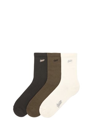 Trois paires de chaussettes en noir, vert olive et blanc. Chacune a une texture côtelée et présente un petit logo brodé près du revers.