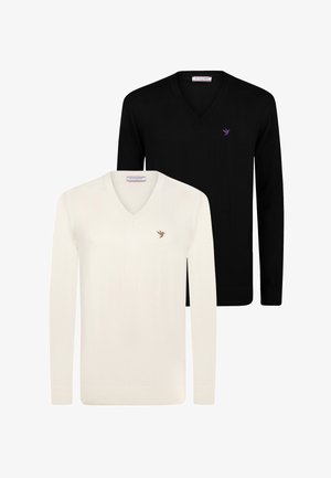 Zwei V-Ausschnitt-Pullover in Weiß und Schwarz. Hergestellt aus weichem Material, mit langen Ärmeln und einem kleinen Vogel-Logo auf der Brust.