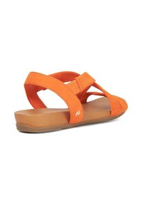 Orange suede sandal with cross-strap design, flat sole, and a light brown platform. Notable gold accent on the side.