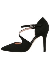 Černá semišová bota na vysokém podpatku s špičatou špičkou, popruhem na kotníku a vystřihnutím v horní části. Elegantní, úzký silueta.
