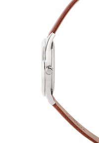 Montre en acier inoxydable avec un profil mince, dotée d'un bracelet en cuir brun et d'une couronne argentée polie. Le bracelet texturé ajoute un contraste.