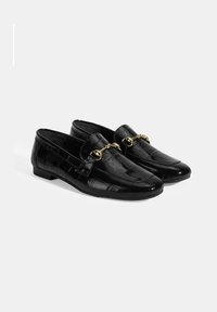 Zwarte leren loafers met een krokodillenstructuur, gouden kettingaccent en lage hak. Gladde afwerking en afgeronde neusdesign.