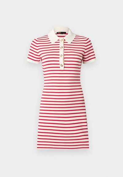Λευκό φόρεμα κοντομάνικο, μήκους έως το γόνατο, με οριζόντιες κόκκινες ρίγες, λευκό γιακά και εμπρόσθια σειρά με τέσσερα κουμπιά.