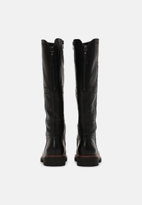 Botas negras de cuero hasta la rodilla con un diseño elegante, que cuentan con dobles cremalleras laterales y paneles texturizados, complementadas por una suela robusta.