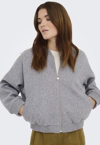 Grijze fleece bomberjack met een ritssluiting voor, geribde boorden en zoom, en zijzakken, met een ontspannen pasvorm en een gestructureerde stof.