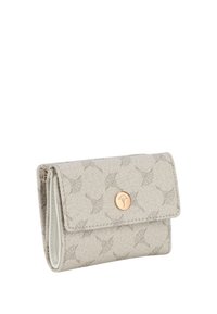 Beige portemonnee van textiel met een bloemenpatroon. Voorzien van een drukknoopsluiting en een klein gouden logoaccent aan de voorkant.
