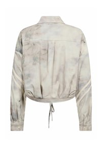 Giacca corta in grigio chiaro con motivo marmo, con colletto classico, bottoni e strisce laterali. Tessuto morbido con orlo regolabile con coulisse.