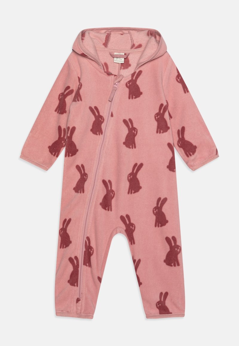Une combinaison en polaire rose avec une fermeture éclair sur le devant, une capuche et un motif répétitif de silhouettes de lapins roses foncés. Manches longues et jambes de pantalon.