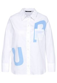 Camicia bianca a maniche lunghe con collo a bottoni; presenta grandi lettere azzurre e una piccola tasca. Materiale in cotone, texture liscia.