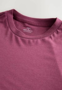 Mørkerød bomulds t-shirt med rund hals, almindelig pasform og glat tekstur. Etiketten indeholder mærke- og størrelsesoplysninger.
