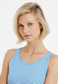 Canotta a righe blu e bianche con scollatura a giro e spalline sottili. Tessuto liscio con texture uniforme, silhouette aderente.