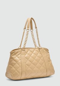 Beige leren totebag met quilted patroon en dubbele schouderbanden, voorzien van gouden kettingaccenten en een ruime indeling met gestructureerde zijkanten.