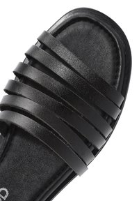 Sandale noire avec plusieurs lanières plates et horizontales sur une semelle rembourrée. Le matériau supérieur a une finition lisse et texturée.