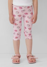 Roze leggings met een schelpenprint, featuring verschillende gekleurde schelpen. Het ontwerp is strakke fitting, cropped tot de kuiten. Draagt bij roze sandalen.