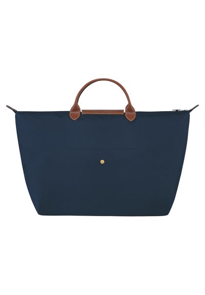 Navy fabric tote bag with brown leather handles and accents, zip closure, and a front pocket featuring a gold hardware detail.