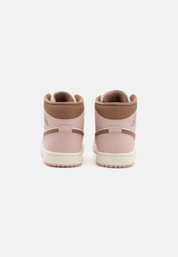 Para wysokich sneakersów z miękkiej różowej i brązowej skóry, pokazanych z tyłu na białym tle.