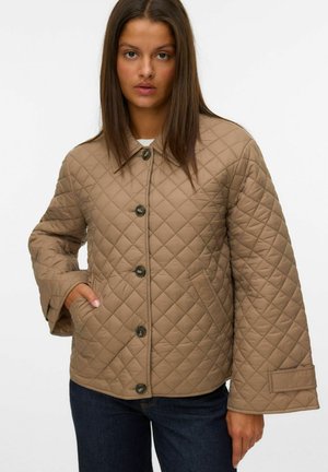 Veste beige matelassée en tissu avec un motif en diamant, dotée d'un col, de boutons à l'avant et de poches latérales. Manches longues avec larges poignets.