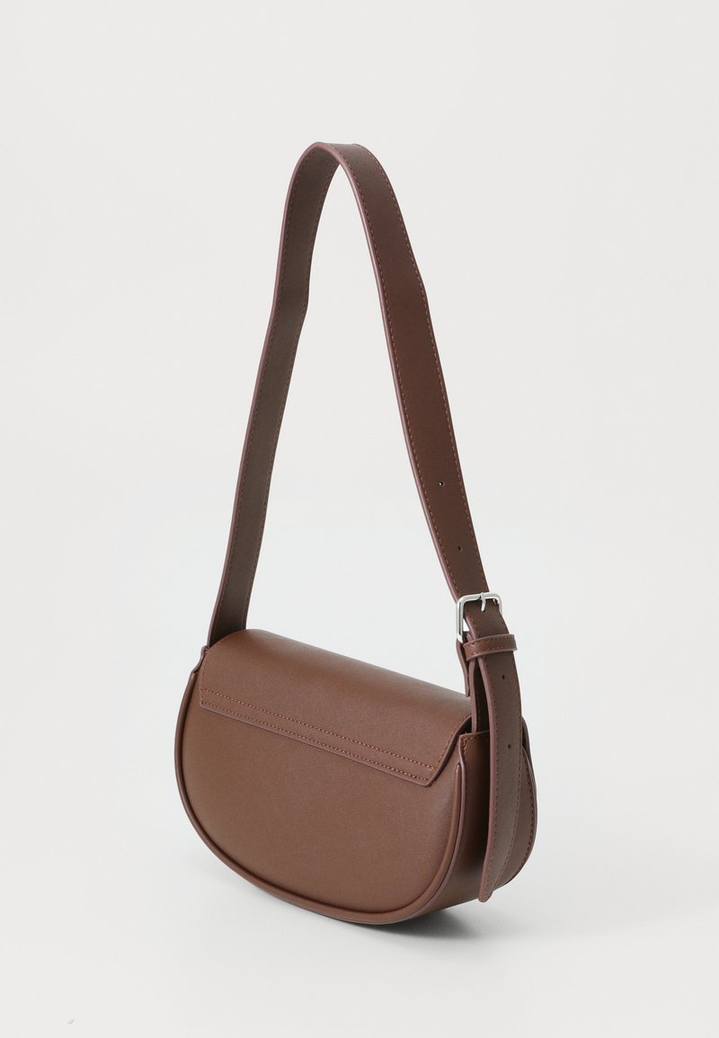 Bolso cruzado marrón hecho de cuero suave, con forma redondeada, correa ajustable y diseño minimalista. Sin herrajes visibles.